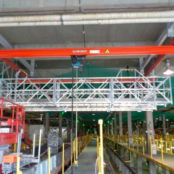 Aluminium loopbrug in een spoorwegwerkplaats Versterkte aluminium loopbrug voor toegang tot treindaken in de werkplaats.